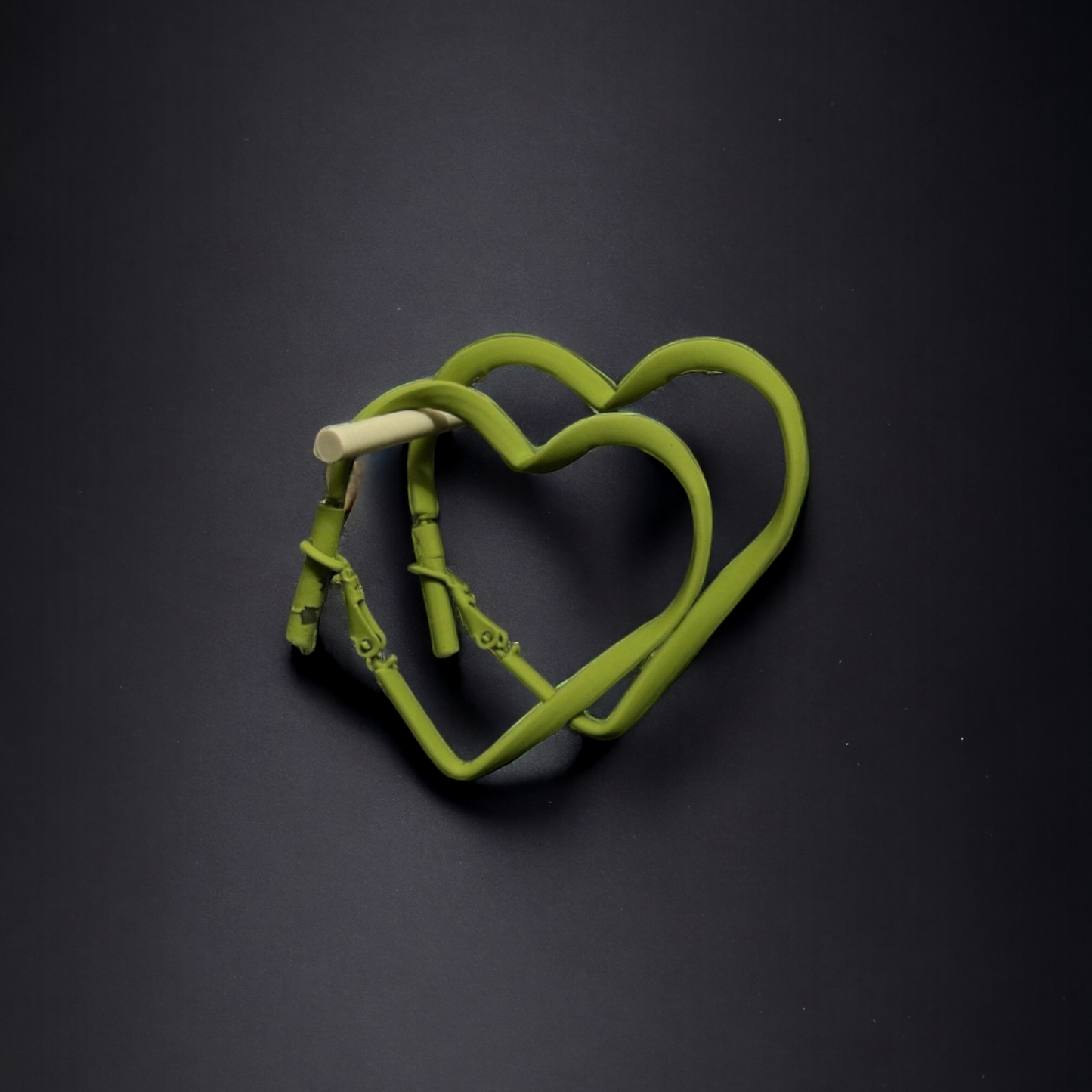 Elegant heart-shaped hoops with a vibrant green accent.