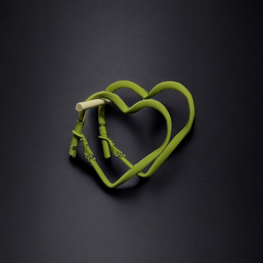 Elegant heart-shaped hoops with a vibrant green accent.